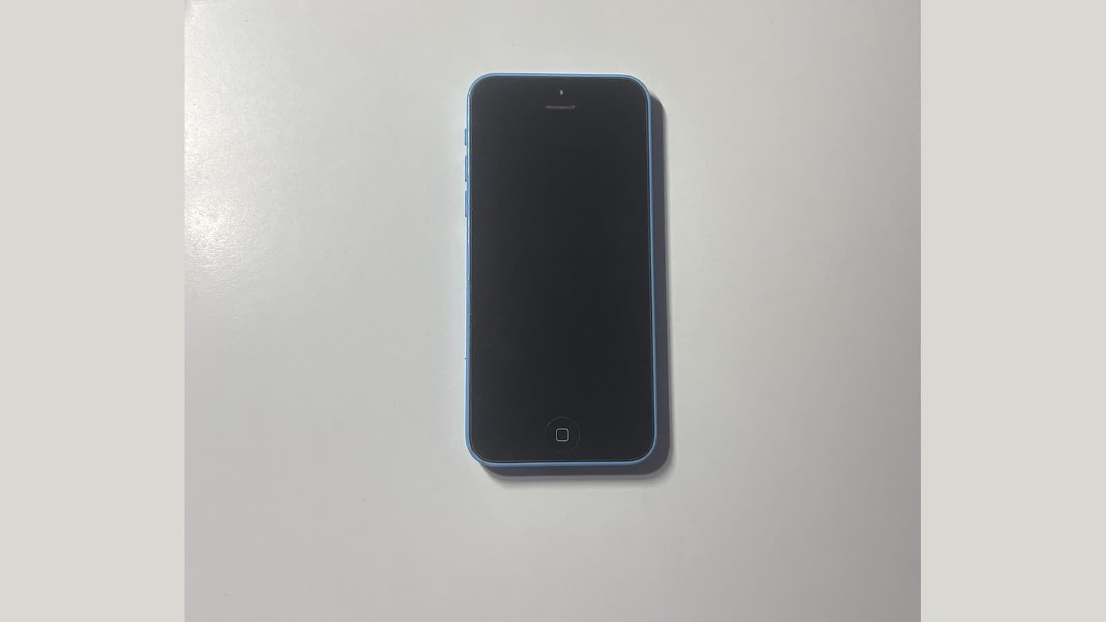 A blue iPhone 5c with its screen off.