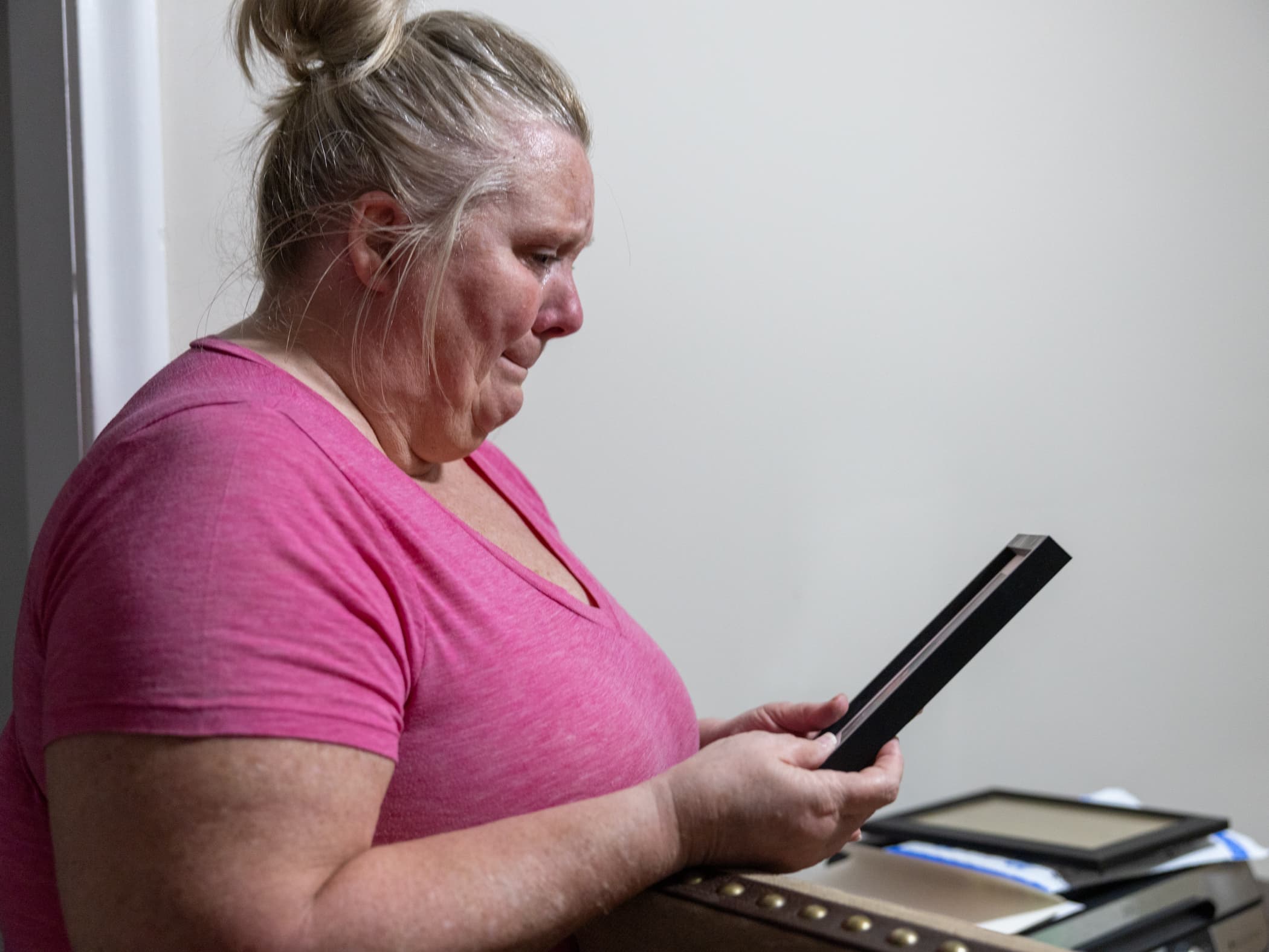 Tracy DeSenti looks at a framed photograph of her late husband, Billy DeSenti.
