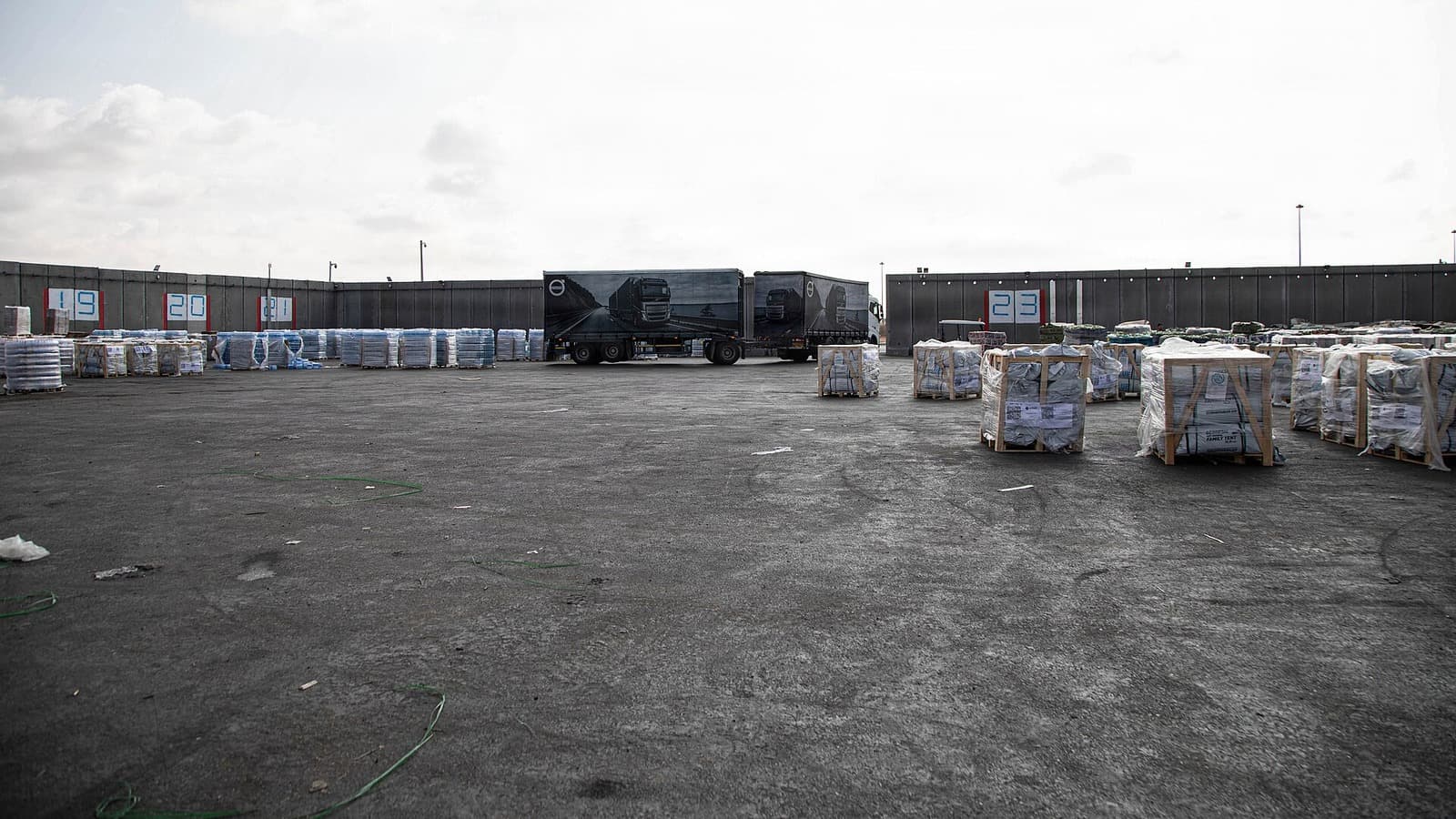 A truck departs an unloading area containing pallets of humanitarian aid at the Kerem Shalom crossing.