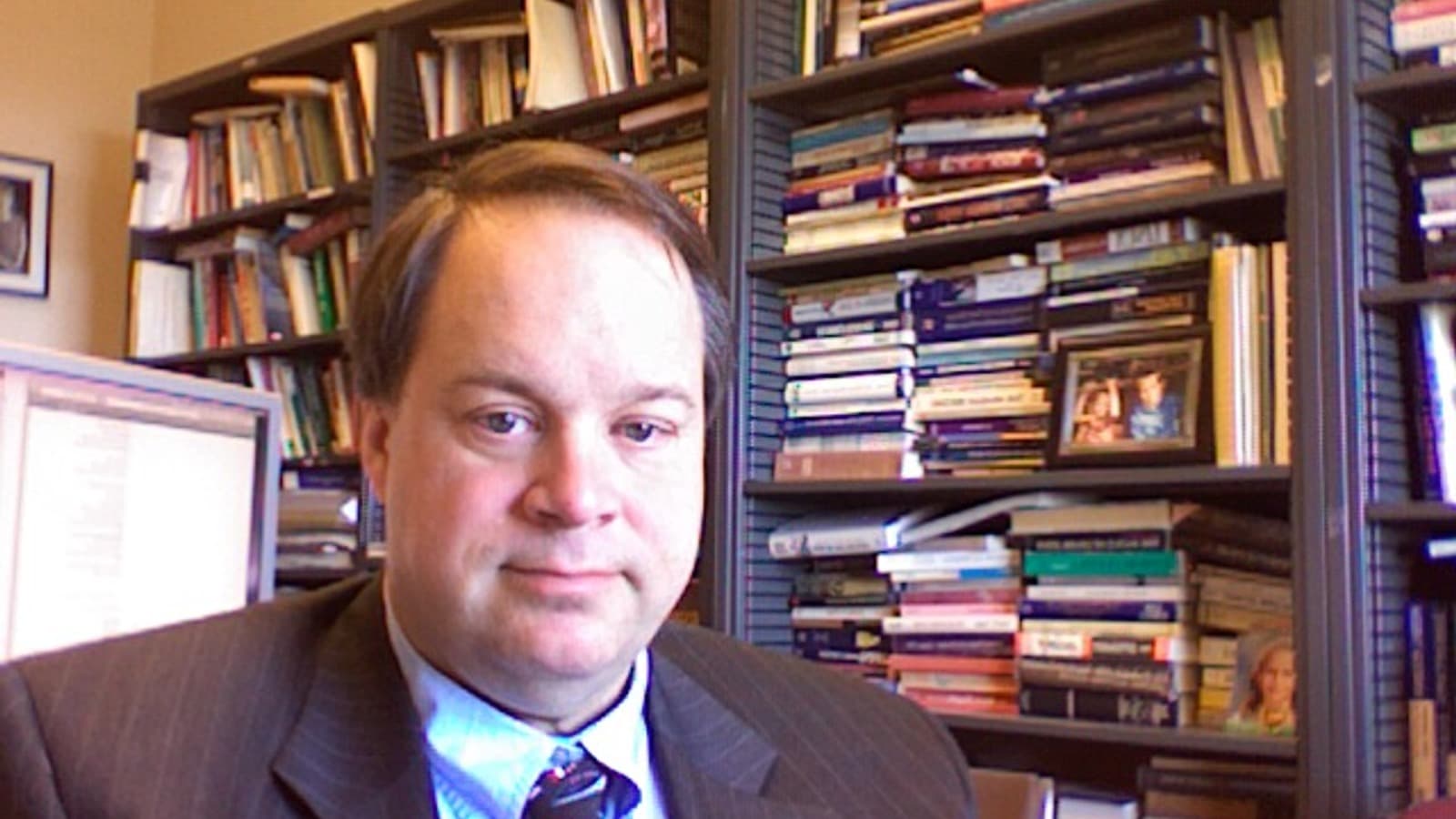 Economist Brad DeLong seated in his office in front of bookshelves.