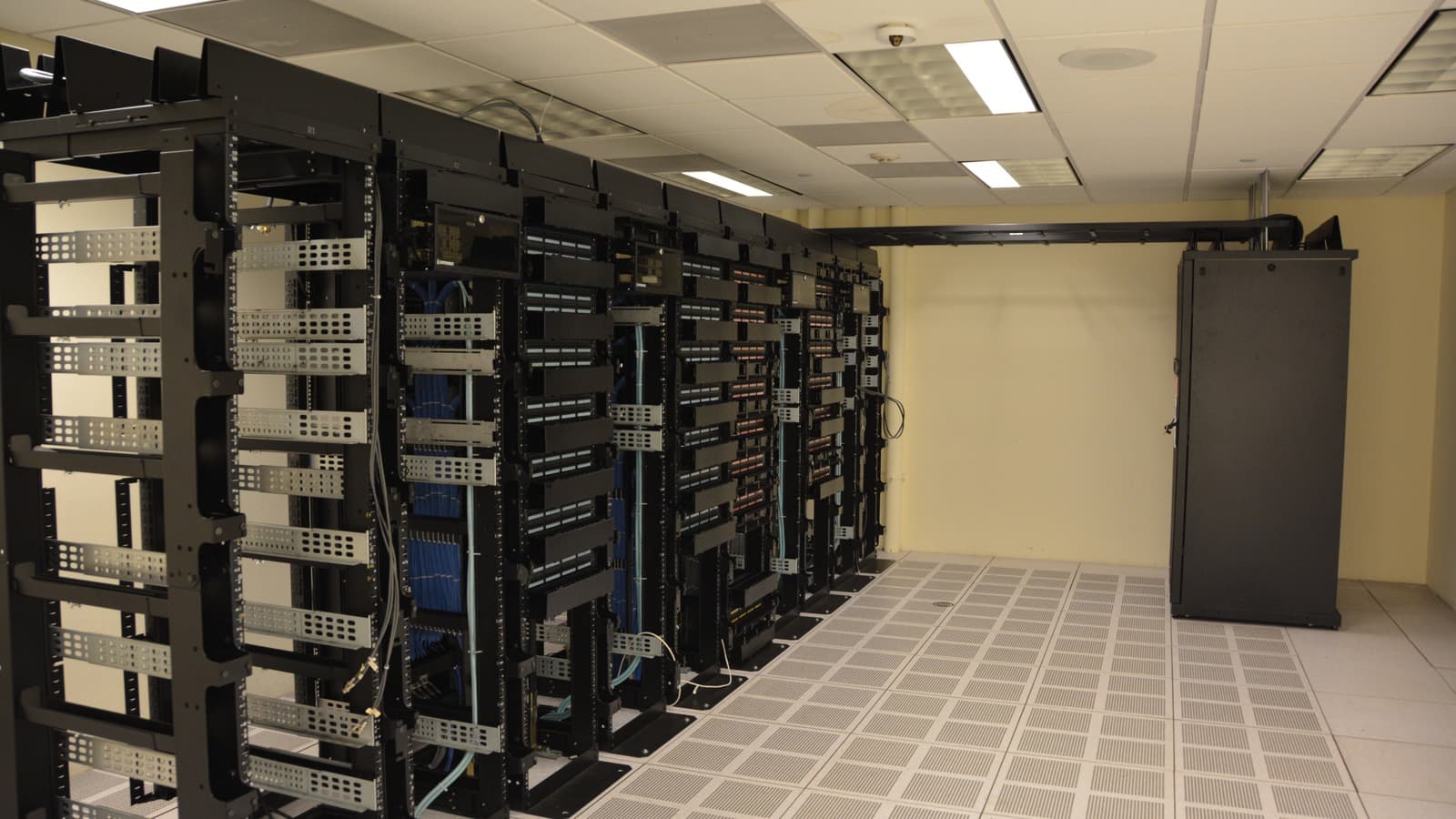 Rows of equipment racks and cables in a data center.