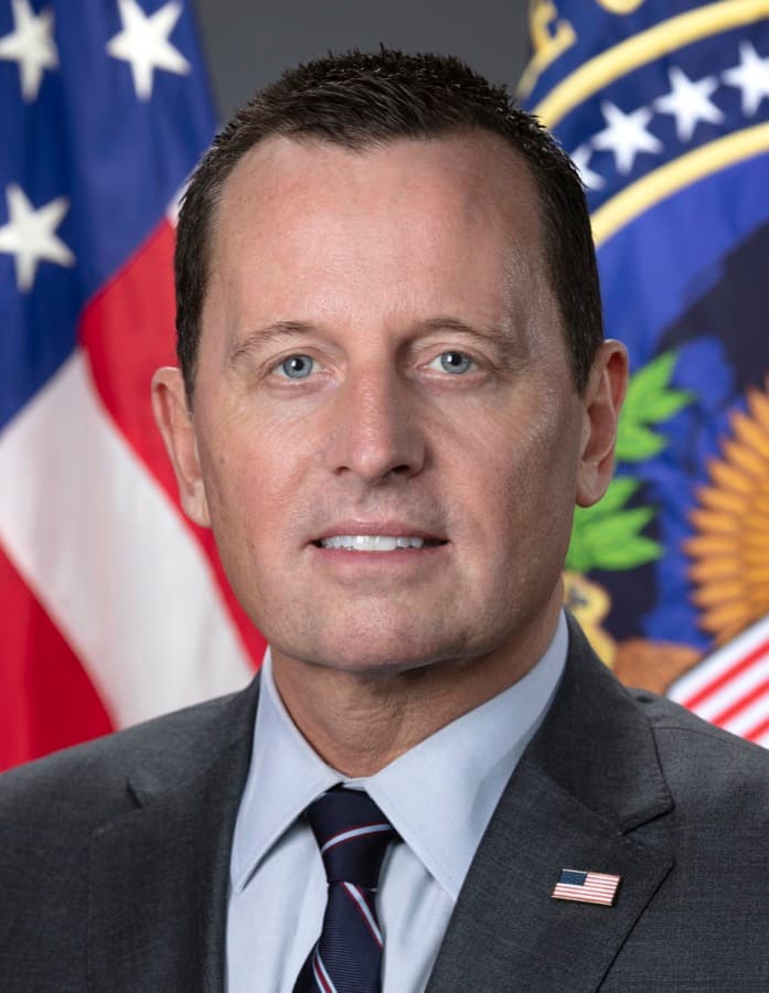 Official portrait of Richard Grenell in a dark suit in front of a U.S. flag.