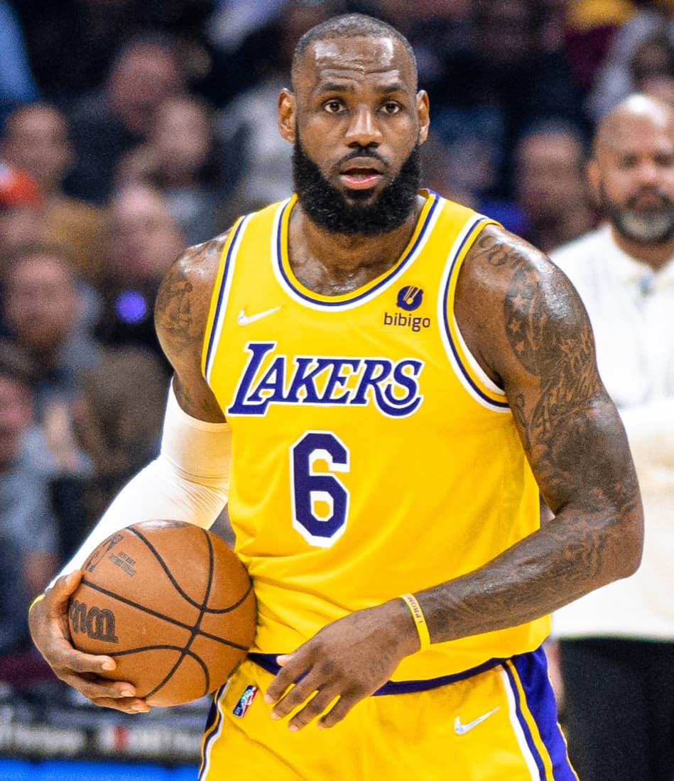 LeBron James, in a yellow Los Angeles Lakers jersey with the number 6, holds a basketball during a game.