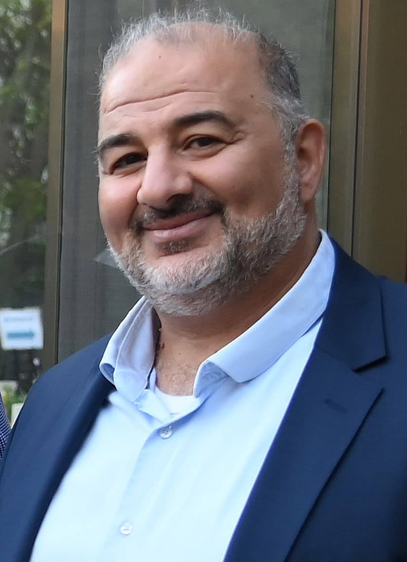 Mansour Abbas, wearing a dark suit and white shirt, at a reception.