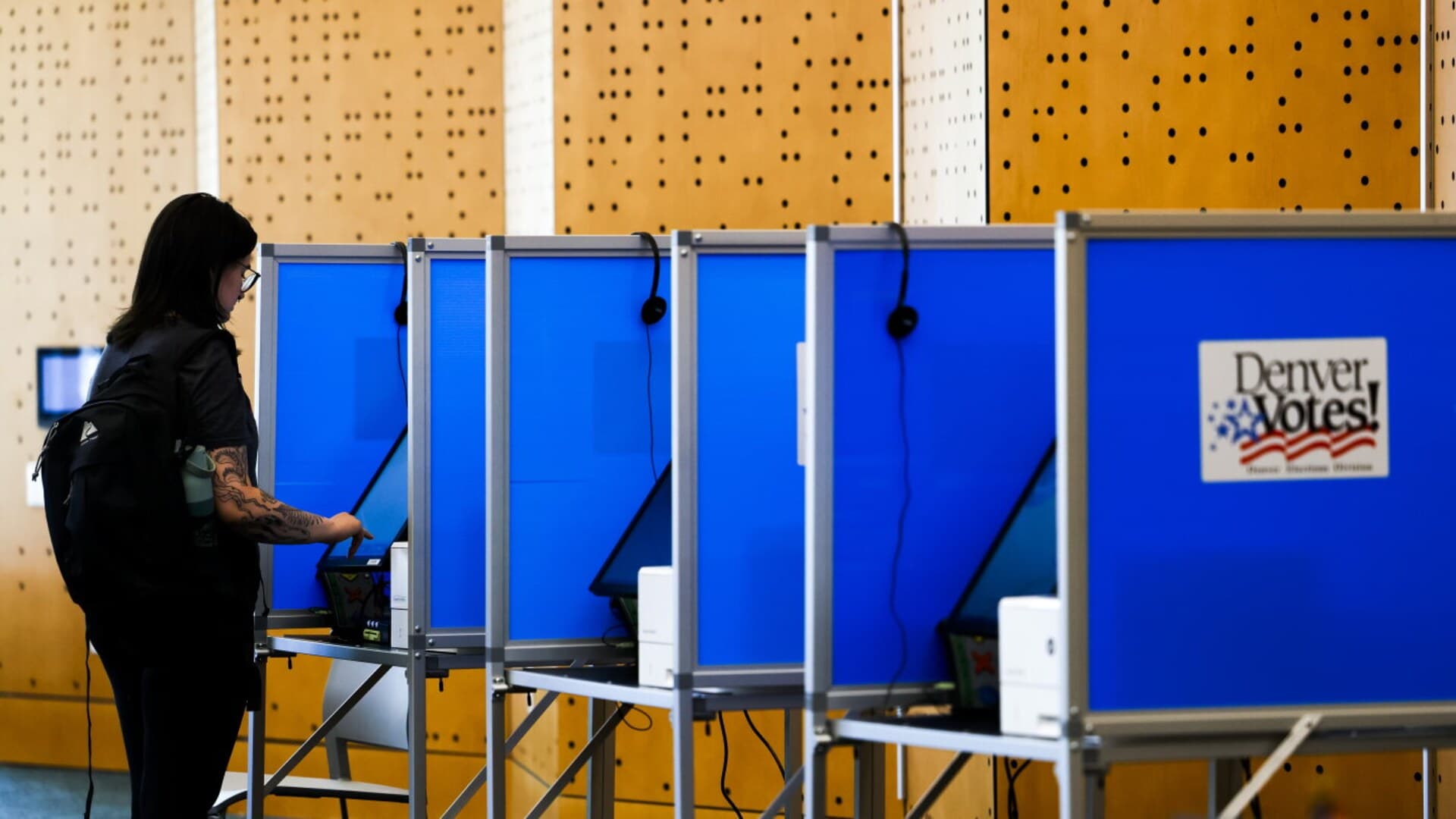 A voter uses a blue voting booth at the Denver Central Library.
