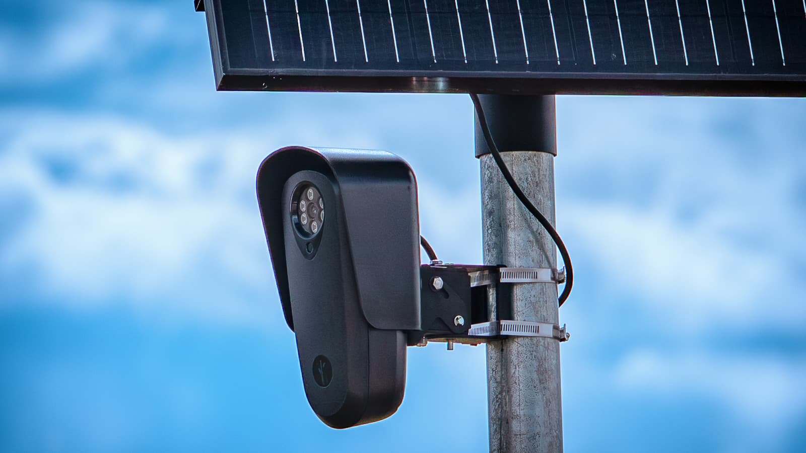 A Flock Safety automated license plate reader mounted below a solar panel.