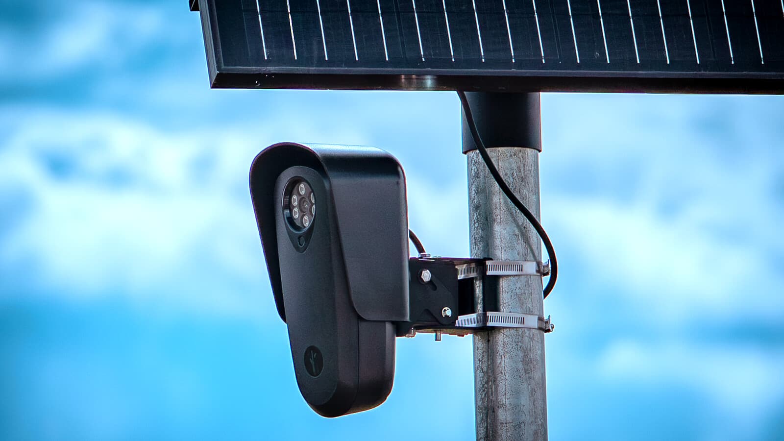 A Flock Safety license-plate reader mounted beneath a solar panel.