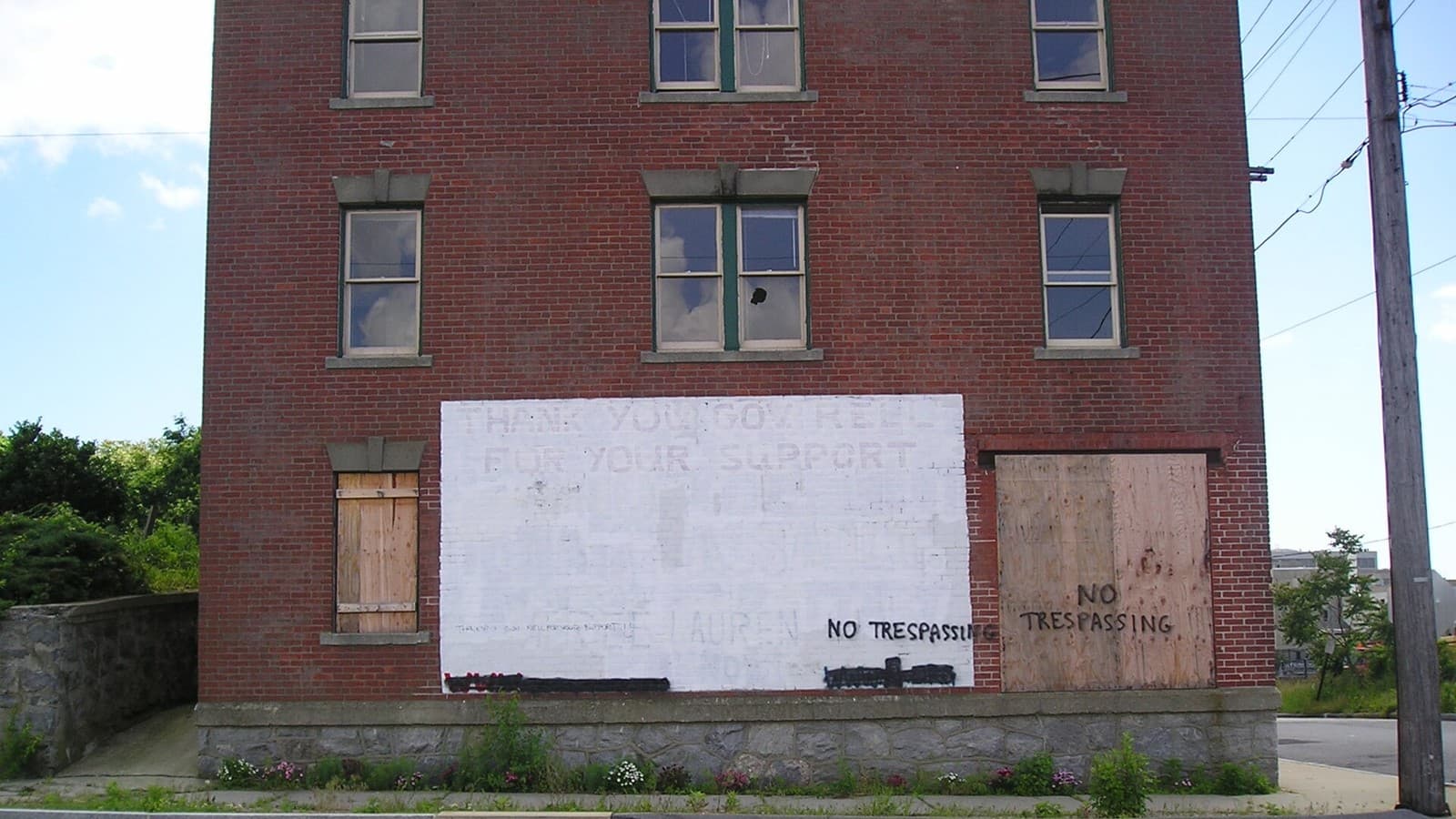 A boarded-up brick building with broken windows in New London's former Fort Trumbull neighborhood.