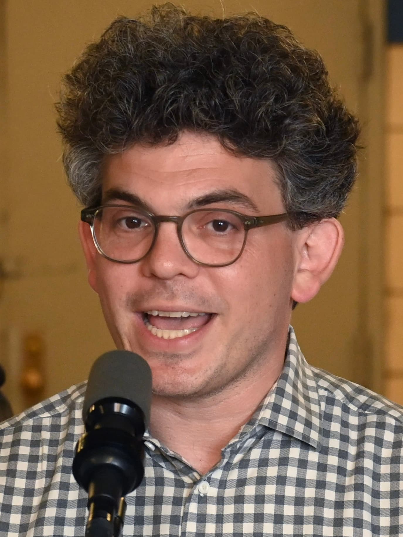 New York City Council Member Lincoln Restler speaking at a microphone.