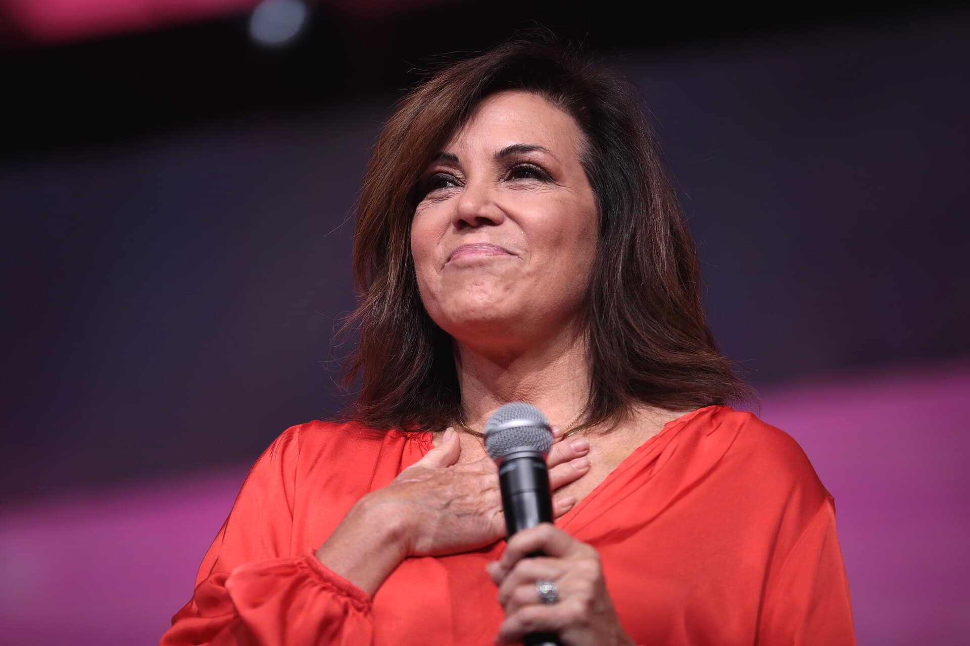 Michele Tafoya speaking into a microphone at a 2023 Young Women’s Leadership Summit event.