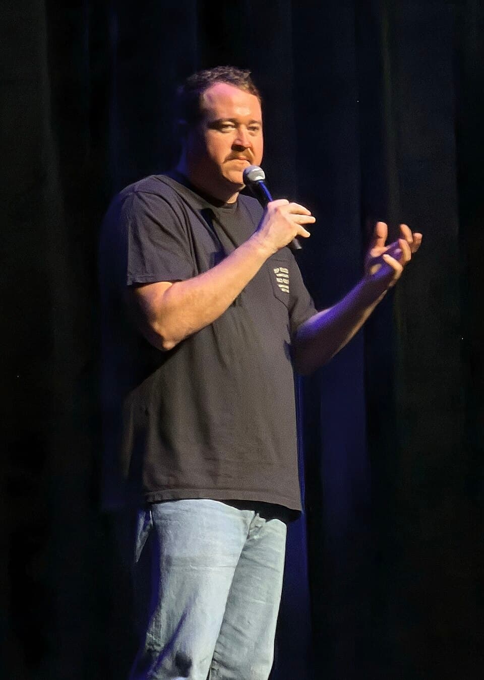 Shane Gillis performing stand-up comedy on stage