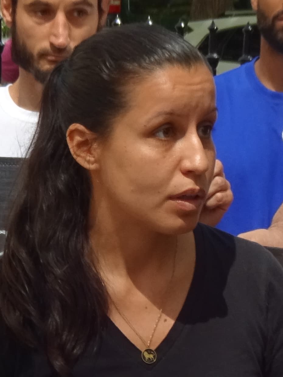 Tiffany Cabán, a New York City Council member, speaking outdoors with other people behind her.