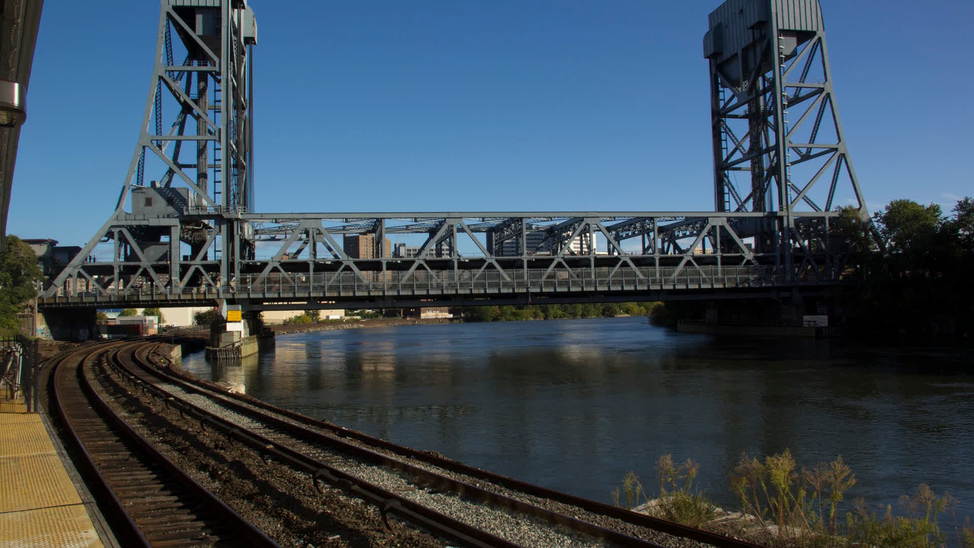 The Broadway Bridge over the Harlem River seen from the Marble Hill Metro-North station, with rail tracks in the foreground.