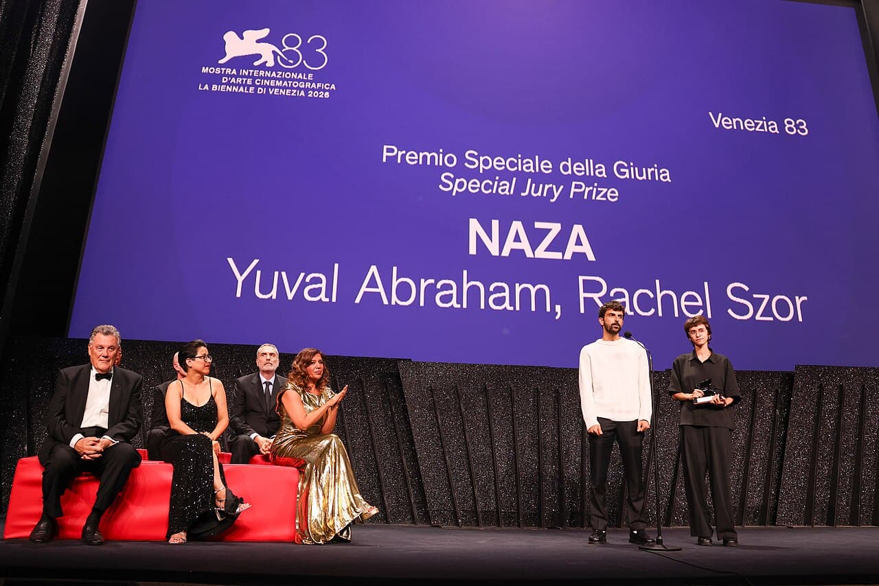 Yuval Abraham and Rachel Szor stand on the stage at the Venice festival's closing ceremony beneath a screen reading Special Jury Prize, NAZA, Yuval Abraham, Rachel Szor.