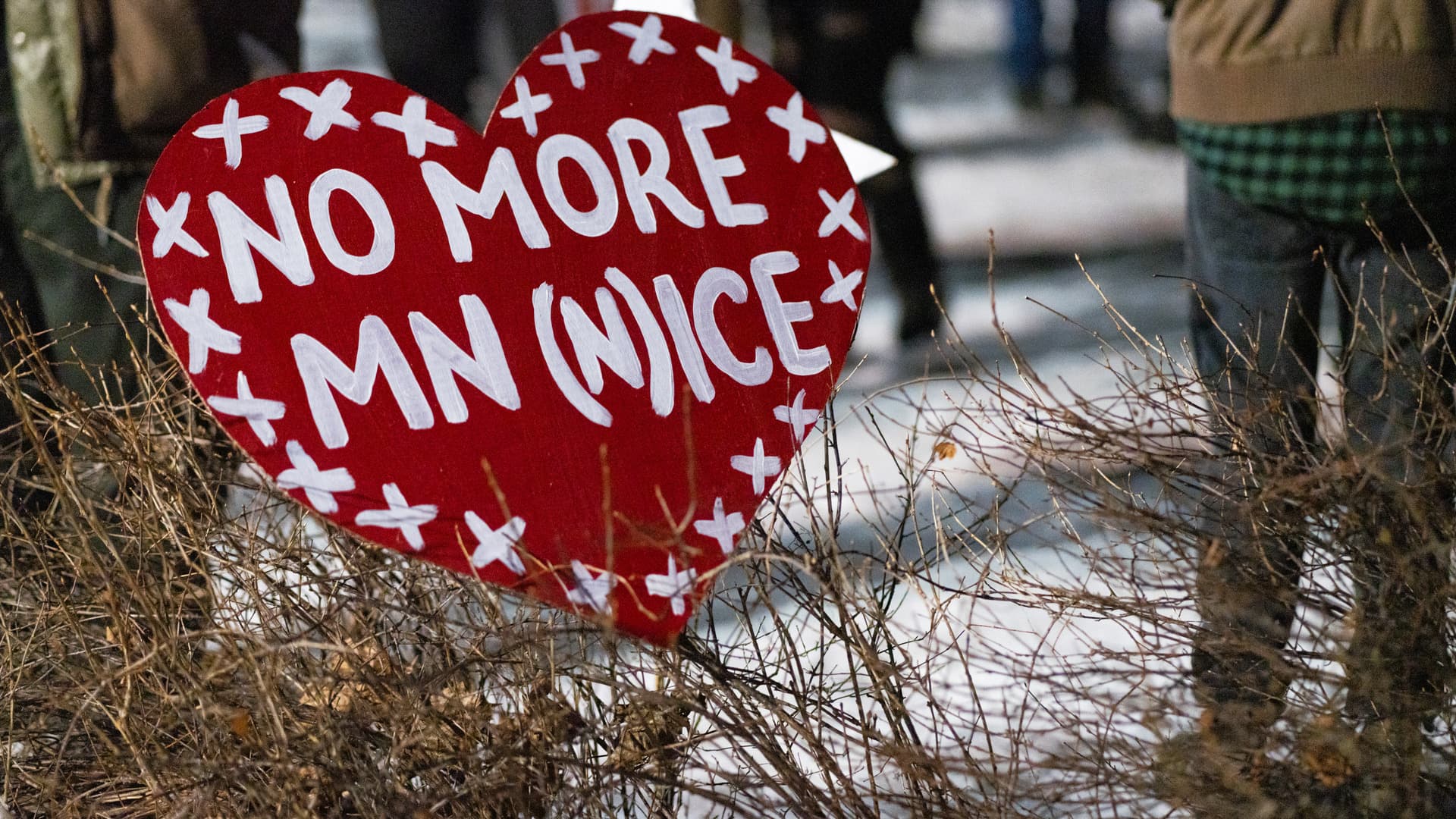 A red heart-shaped sign at a Minneapolis vigil reads No More MN (N)ice.