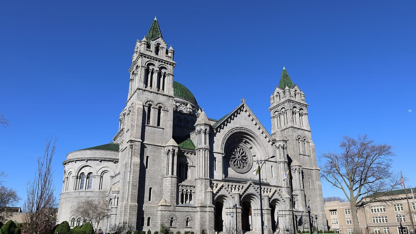 The stone facade, towers and green dome of the Cathedral Basilica of Saint Louis.